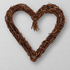 May include: A heart-shaped wreath constructed from intertwined brown twigs and branches. The structure features a rustic, natural texture with a small bundle of loose twig ends tied together at the top center of the heart shape.
