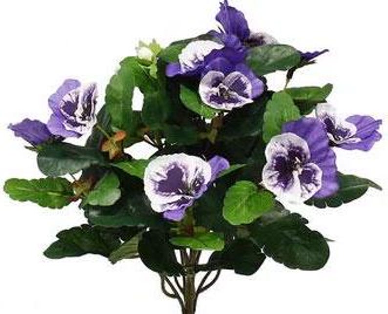 May include: A bouquet of artificial purple and white pansies with green leaves.