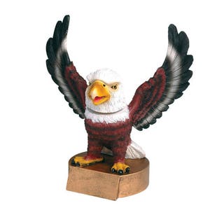 May include: A bald eagle figurine with outstretched wings, perched on a gold-colored base. The eagle has a white head and tail feathers, with brown and black feathers on its body. The eagle's beak is open, and its eyes are closed.