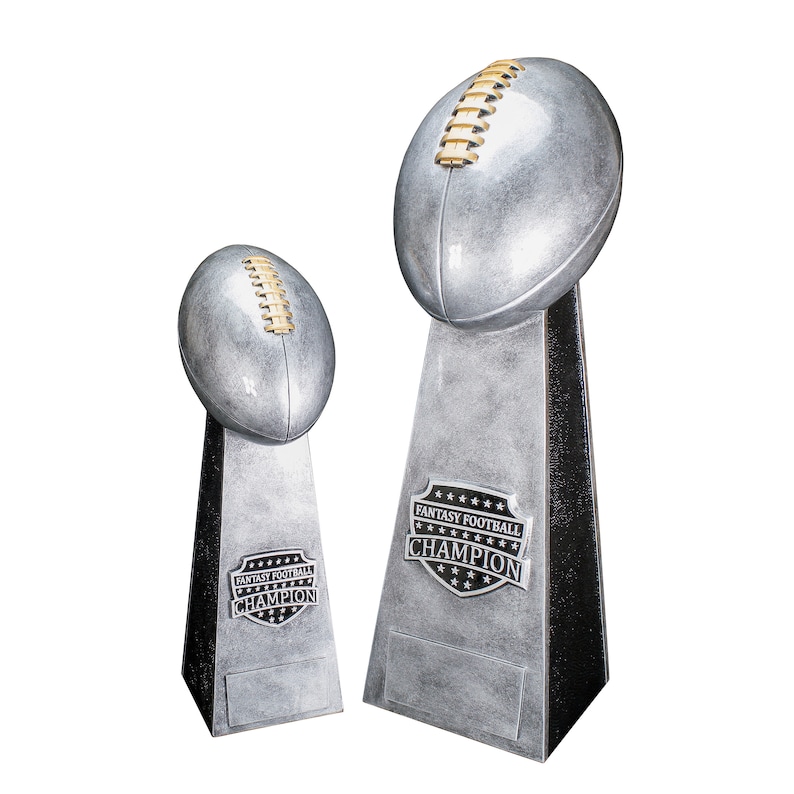 K&ouml;nnte beinhalten: Zwei silberne Fu&szlig;balltroph&auml;en mit schwarzen Sockeln. Die gr&ouml;&szlig;ere Troph&auml;e hat einen silbernen Fu&szlig;ball obenauf und eine schwarz-silberne Plakette mit der Aufschrift "Fantasy Football Champion". Die kleinere Troph&auml;e hat einen silbernen Fu&szlig;ball obenauf und eine schwarz-silberne Plakette mit der Aufschrift "Fantasy Football Champion".