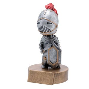 May include: A silver and gold knight figurine holding a sword and shield. The knight is wearing a helmet with a red plume. The figurine is standing on a gold base.