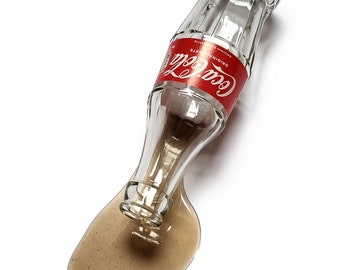 Gevallen glazen coca cola, omgevallen kunst object, cola kunst.