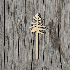 May include: A wooden cutout of a pine tree on a weathered gray wood background.