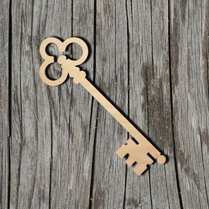 May include: A wooden key cutout with a decorative, ornate design. The key is light brown and has a classic, vintage style.