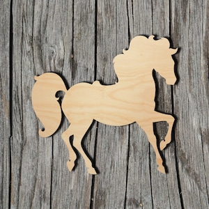 May include: A wooden horse silhouette with a flowing mane and tail, posed in a running stance. The horse is cut from light-colored wood and set against a weathered, gray wooden background.
