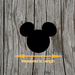 K&ouml;nnte beinhalten: Schwarze Silhouette von Mickey Mouse Kopf auf einem Holz Hintergrund. Die Silhouette wird in der L&auml;nge mit einem orangefarbenen Pfeil gemessen.
