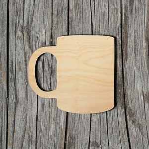 May include: A wooden cutout of a coffee mug, with a handle, on a wood background.