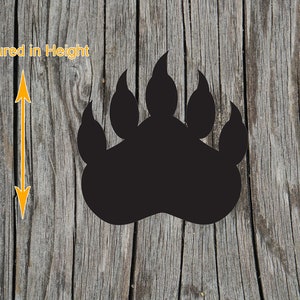 May include: A solid black bear paw print silhouette featuring five distinct claw marks at the top. To the left of the paw print, a yellow double-headed arrow indicates the vertical orientation with the text Measured in Height.
