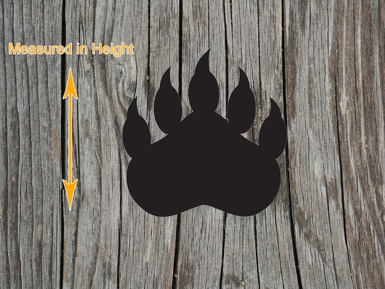 May include: A solid black bear paw print silhouette featuring five distinct claw marks at the top. To the left of the paw print, a yellow double-headed arrow indicates the vertical orientation with the text Measured in Height.