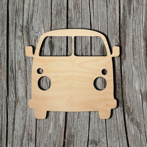 May include: A wooden cutout of a vintage van, painted in a light brown color. The van has a rounded front with two circular headlights and a windshield.