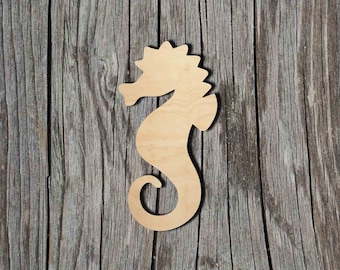 May include: A wooden cutout of a seahorse in a light brown color. The cutout is on a gray wooden background.