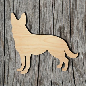 May include: A wooden cutout of a German Shepherd dog silhouette. The cutout is made of light brown wood and is standing on a wood background.