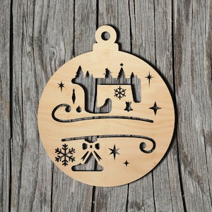 May include: A wooden Christmas ornament shaped like a round ball with a polar bear and a snowflake design. The ornament is cut out with a laser and has a rustic look.