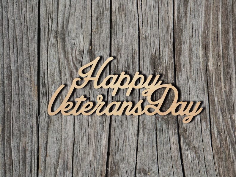 May include: Wooden sign with the text "Happy Veterans Day" in a cursive font, against a woodgrain background.
