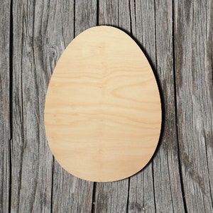May include: A light brown wooden egg shape, with a smooth surface, against a weathered wood background.