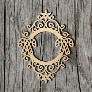 May include: A wooden Christmas ornament shaped like a frame with a candy cane design and a snowflake at the top.