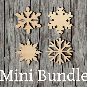 May include: Four wooden snowflake ornaments in a mini bundle. The snowflakes are cut from natural wood and have a light brown color. The snowflakes are arranged in a square pattern on a gray wooden background. The text "Mini Bundle" is written in white letters below the snowflakes.