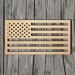 May include: A wooden cutout of the American flag with red, white, and blue stripes and 50 stars. The flag is on a gray wooden background.