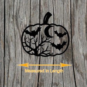May include: Black pumpkin-shaped Halloween decoration with bats, a crescent moon, and tree branches cut out. The decoration is placed on a wooden surface. The text "Measured in Length" is below the pumpkin.