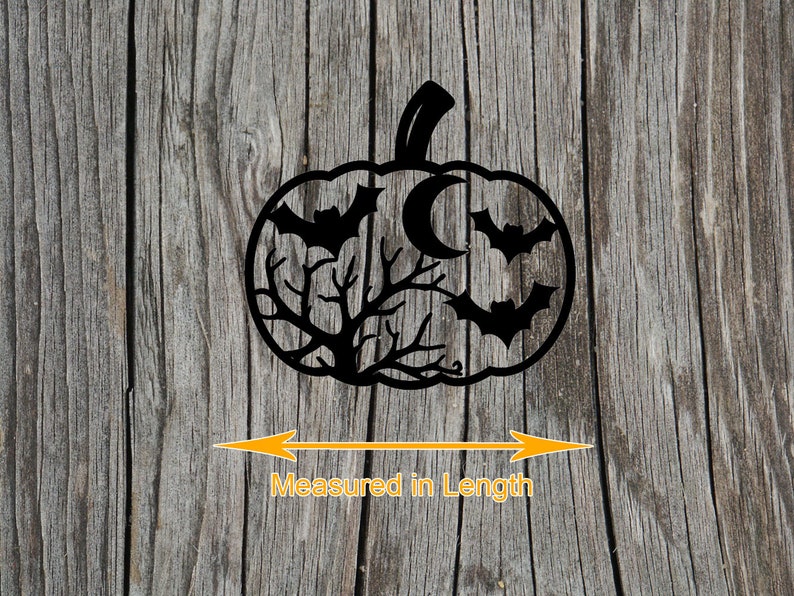 May include: Black pumpkin-shaped Halloween decoration with bats, a crescent moon, and tree branches cut out. The decoration is placed on a wooden surface. The text "Measured in Length" is below the pumpkin.