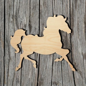 May include: A wooden cutout of a horse in a running pose. The horse is made of light brown wood and has a simple, elegant design.