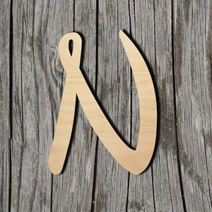 May include: Wooden letter N in a cursive style, cut from natural wood, against a rustic wood background.
