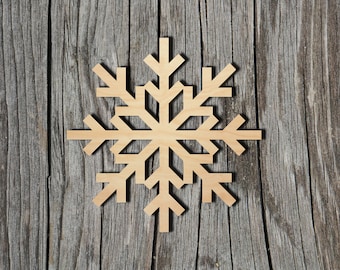 May include: A light-colored, flat, wooden snowflake cutout featuring a six-pointed geometric design with symmetrical branches and angled tips. The snowflake has a smooth, natural wood grain finish and is presented as a single, die-cut decorative piece.