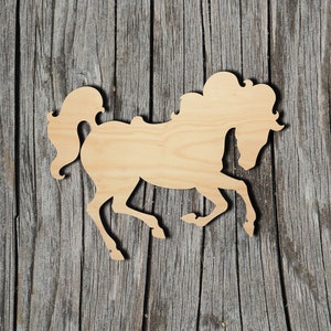 May include: A wooden cutout of a horse in a running pose. The cutout is made of light brown wood and has a smooth, unfinished surface.
