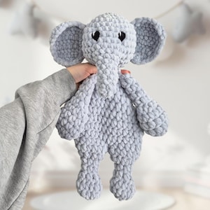 Könnte beinhalten: Ein graues gehäkeltes Elefanten-Plüschtier mit schwarzen Augen. Der Elefant steht auf seinen vier Beinen und hat einen langen Rüssel.