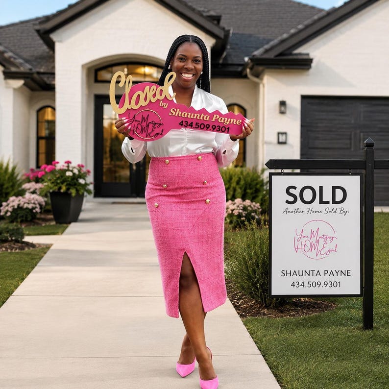 May include: A large pink prop key with gold lettering that reads Closed by Shaunta Payne 434.509.9301 and You Matzay HOMEgurl. The key is held in front of a white satin long-sleeve blouse and a high-waisted pink tweed midi skirt with gold buttons.