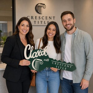 May include: A large, dark green, key-shaped sign with white lettering that reads Closed with Crescent Title, featuring a white pillar logo. The sign is held by three smiling individuals in an office setting with a Crescent Title wall sign.