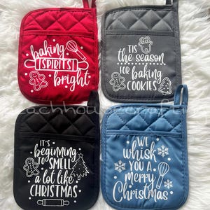 May include: Four quilted pot holders in red, gray, black, and blue. Each has a pocket and a loop for hanging. White text on each reads: "Baking spirits bright," "Tis the season for baking cookies," "It's beginning to smell a lot like Christmas," and "We whisk you a Merry Christmas."