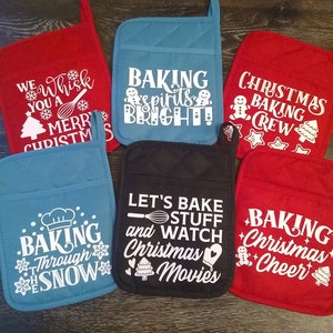 May include: Six different Christmas-themed oven mitts. The mitts are red, blue, and black with white text. The text on the mitts includes "Baking Spirits Bright", "Christmas Baking Crew", "Baking Through the Snow", "Let's Bake Stuff and Watch Christmas Movies", and "Baking Christmas Cheer".