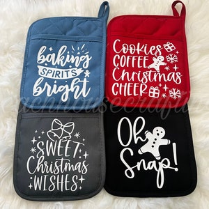 May include: Four Christmas-themed pot holders in blue, red, gray, and black. Each pot holder has a pocket and a loop for hanging. White text includes phrases like "Baking Spirits Bright" and "Oh Snap!"