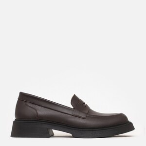 K&ouml;nnte beinhalten: Ein brauner Lederloafer mit einer klobigen schwarzen Sohle. Der Schuh hat ein klassisches Penny-Loafer-Design mit runder Spitze und niedrigem Absatz. Der Schuh ist aus glattem, strukturiertem Leder gefertigt.