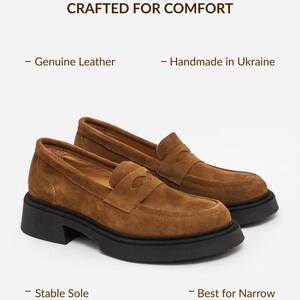 Może przedstawiać: Brązowe mokasyny z zamszu z grubą czarną gumową podeszwą i paskiem z wycięciem. Tekst na obrazku brzmi: CRAFTED FOR COMFORT, Genuine Leather, Handmade in Ukraine, Stable Sole, Best for Narrow & Regular Feet.