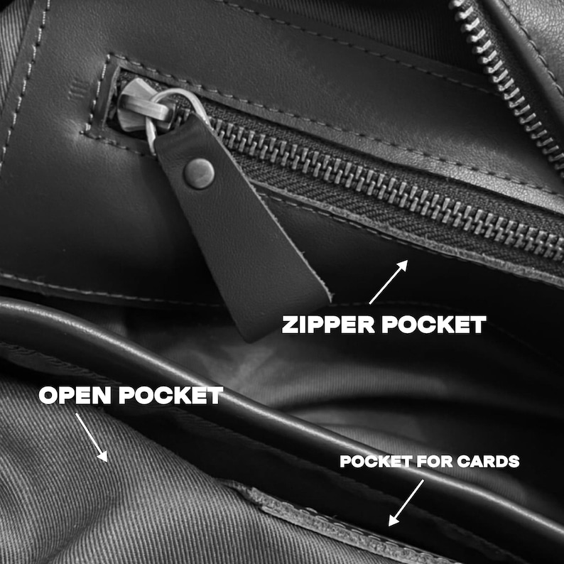May include: Close-up of a black leather bag interior with multiple compartments. Features include a zippered pocket, an open pocket, and a pocket for cards. The bag has a sleek, minimalist design with visible stitching and a leather zipper pull.