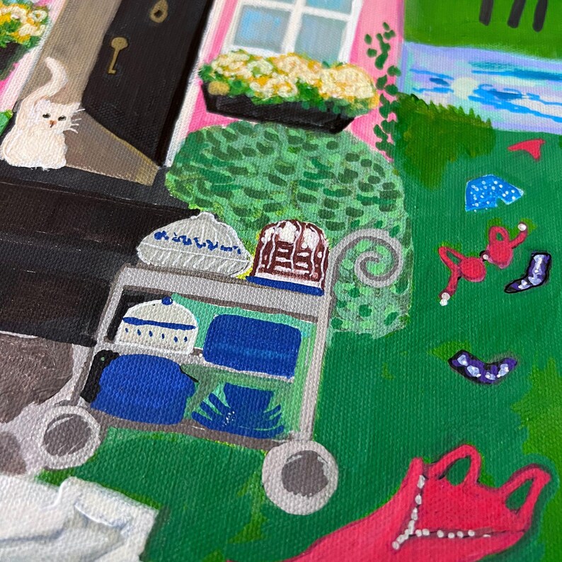 May include: An acrylic painting depicts a whimsical scene with a pink house, a white cat, and a garden. A cart holds blue and white ceramic pieces. The painting has a naive art style with bright colors and a playful atmosphere.