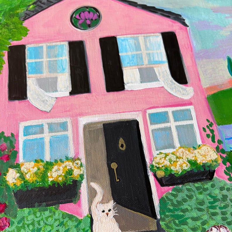 May include: A pink house painting with black shutters and a black door. White cat is at the door. Yellow and white flowers in window boxes. Green foliage and a purple flower above the windows.