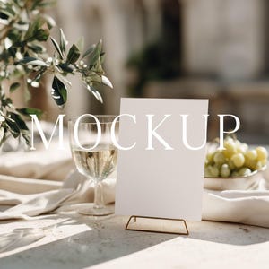 Op de afbeelding: Een witte keramische mok met een zwart handvat en de tekst "But First, Coffee" in een vetgedrukte, zwarte letter. De mok staat tegen een vage achtergrond. De mok is ongeveer 10 cm hoog.