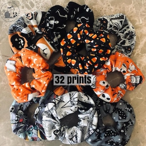 Puede incluir: Una colección de coleteros con temática de Halloween en varios colores y diseños. Los coleteros presentan diseños como caramelos de maíz, esqueletos, murciélagos y calabazas. El texto "32 prints" es visible en la imagen.