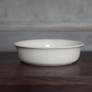 Puede incluir: Un juego de tres tazas de cerámica con acabado mate y moteado. Las tazas son de color crema, gris claro y gris oscuro. Cada taza tiene un diseño simple y minimalista.