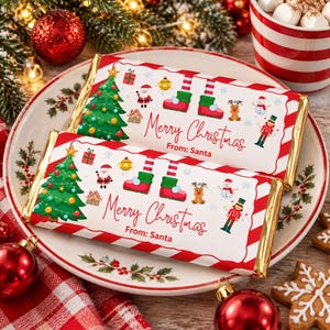 Könnte beinhalten: Zwei rechteckige Schokoladentafeln in weißem Papier mit rot-weiß gestreiften Rändern. Die Verpackungen zeigen einen grünen Weihnachtsbaum, den Weihnachtsmann, Elfenbeine, ein Rentier, einen Schneemann, einen Nussknacker und den Text Merry Christmas From: Santa.