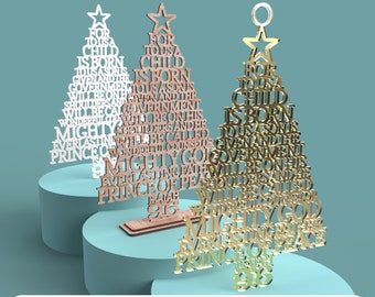 May include: Two laser cut Christmas tree ornaments with the words "For to us a child is born, to us a son is given, and the government will be on his shoulders, and his name will be called Wonderful Counselor, Mighty God, Everlasting Father, Prince of Peace" in white and gold.
