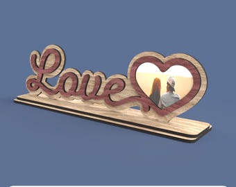 May include: A wooden photo frame with the word "Love" in cursive script. The heart-shaped frame holds a photo of a couple. The frame is made of light and dark wood, with the text "DIGITAL FILE FOR LASER CUTTING".