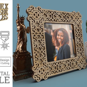 May include: A laser cut wooden picture frame with an intricate design. The frame is brown and has a cutout design that resembles a floral pattern. The frame is sitting on a blue surface.