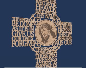 May include: A laser-cut wooden cross featuring the Lord's Prayer text integrated into the structure. A circular center panel displays an engraved portrait of Jesus wearing a crown of thorns. The text reads Our Father Who Art In Heaven Hallowed Be Thy Name Thy Kingdom Be Done As It Is In Heaven Give Us This Day Our Daily Bread And Forgive Us Our Trespasses As We Forgive Those Who Trespass Against Us And Lead Us.