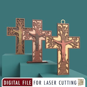 May include: Three layered wooden cross ornaments featuring a central figure integrated into a tree design. Each cross displays different wood tones and textures. The text at the bottom reads DIGITAL FILE FOR LASER CUTTING THE LASER FILES.