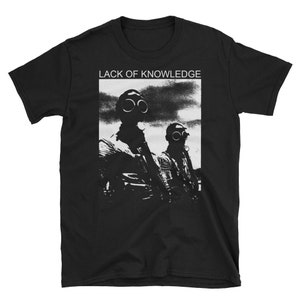 Könnte beinhalten: Schwarzes T-Shirt mit einer weißen Grafik von zwei Personen mit Gasmasken. Der Text "Lack of Knowledge" ist über der Grafik gedruckt.