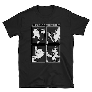 Puede incluir: Camiseta negra con un gráfico blanco de cuatro miembros de la banda "And Also The Trees".